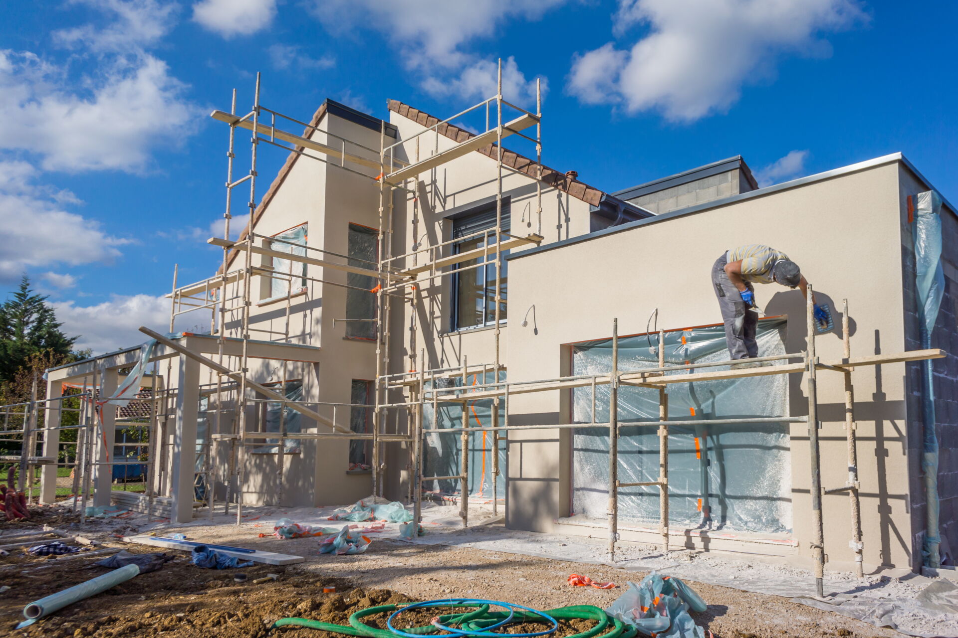 Neubau eines modernen Einfamilienhauses mit Gerüst und Handwerker bei der Arbeit, ein Projekt vom Dienstleistungsbetrieb René Pötschke.