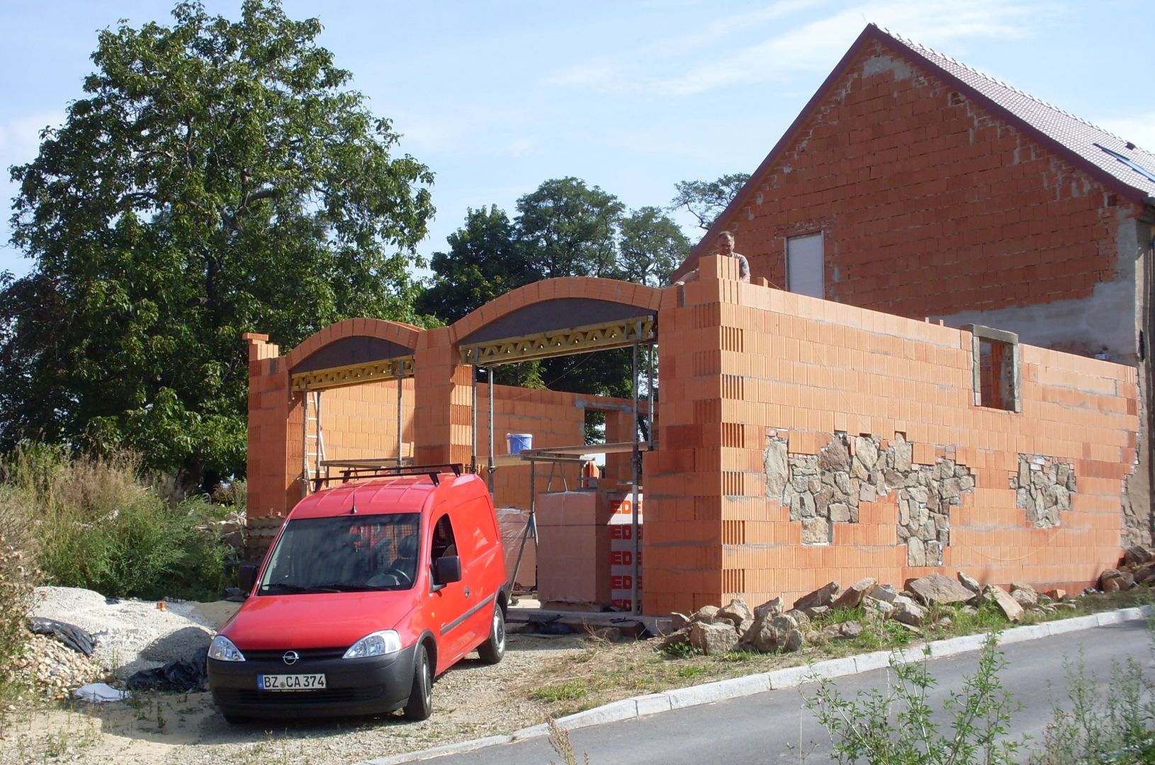 Referenz - Hochbau - Anbau einer Garage und davor steht ein Auto von Pötschke
