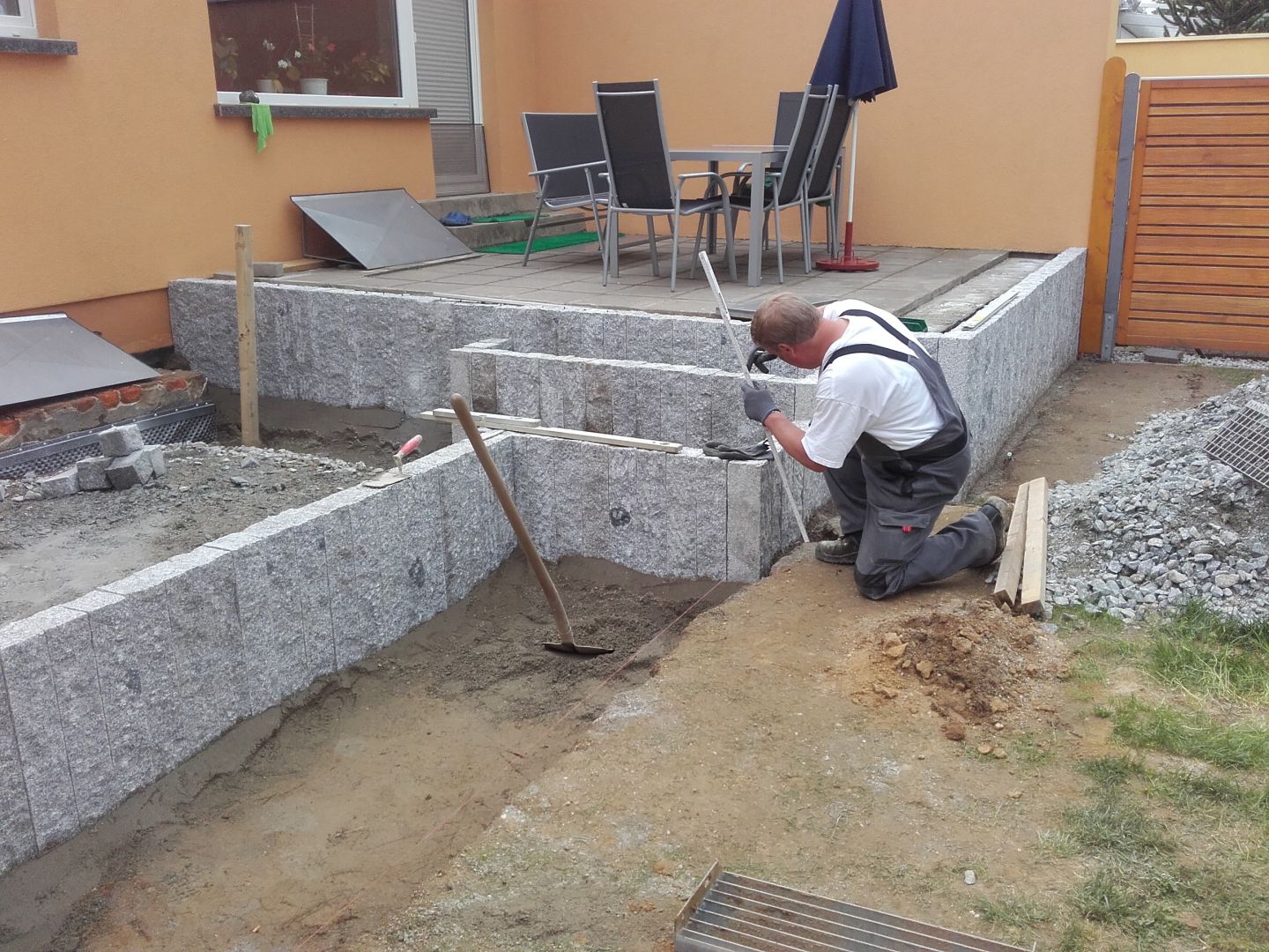 Terrassengestaltung mit grauen Natursteinmauern und Pflasterarbeiten durch einen Handwerker in Bautzen.